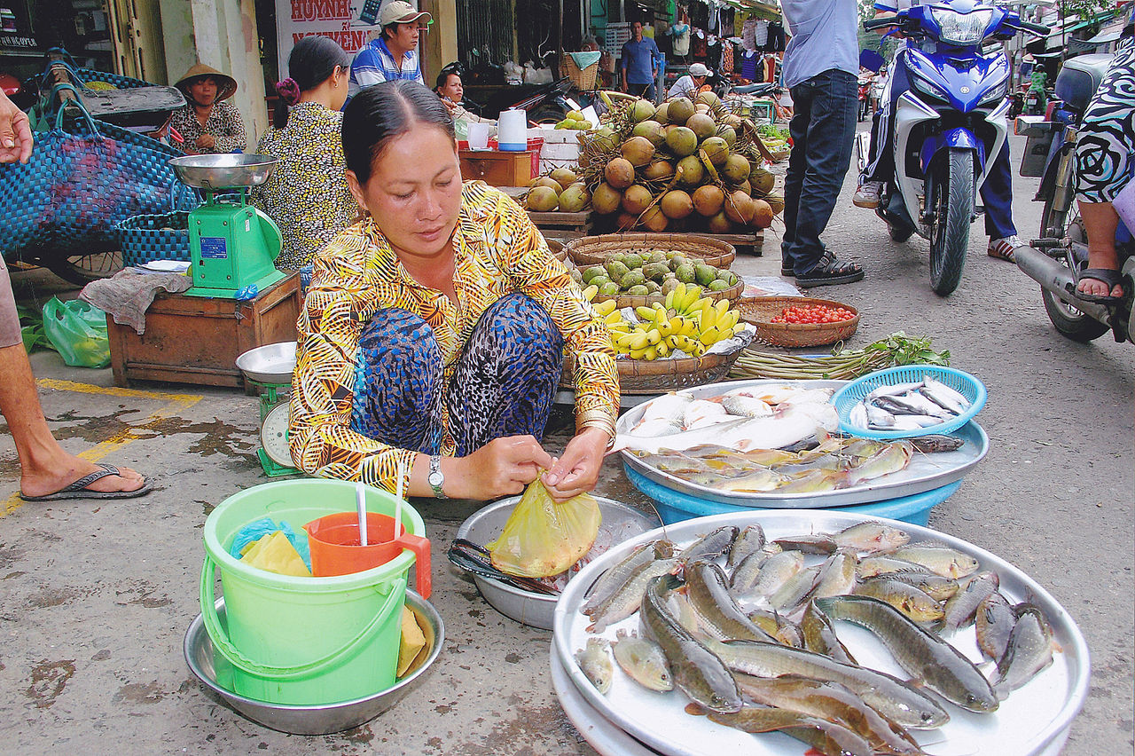 Người bán cá tại chợ Việt Nam minh họa bước cân và xác nhận giá khi ăn hải sản Đà Nẵng