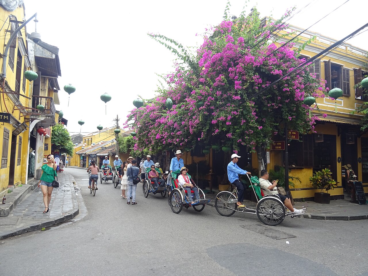 Xe đạp và xích lô trên đường phố Hội An minh họa việc so chi phí theo cả chặng và điều kiện sử dụng
