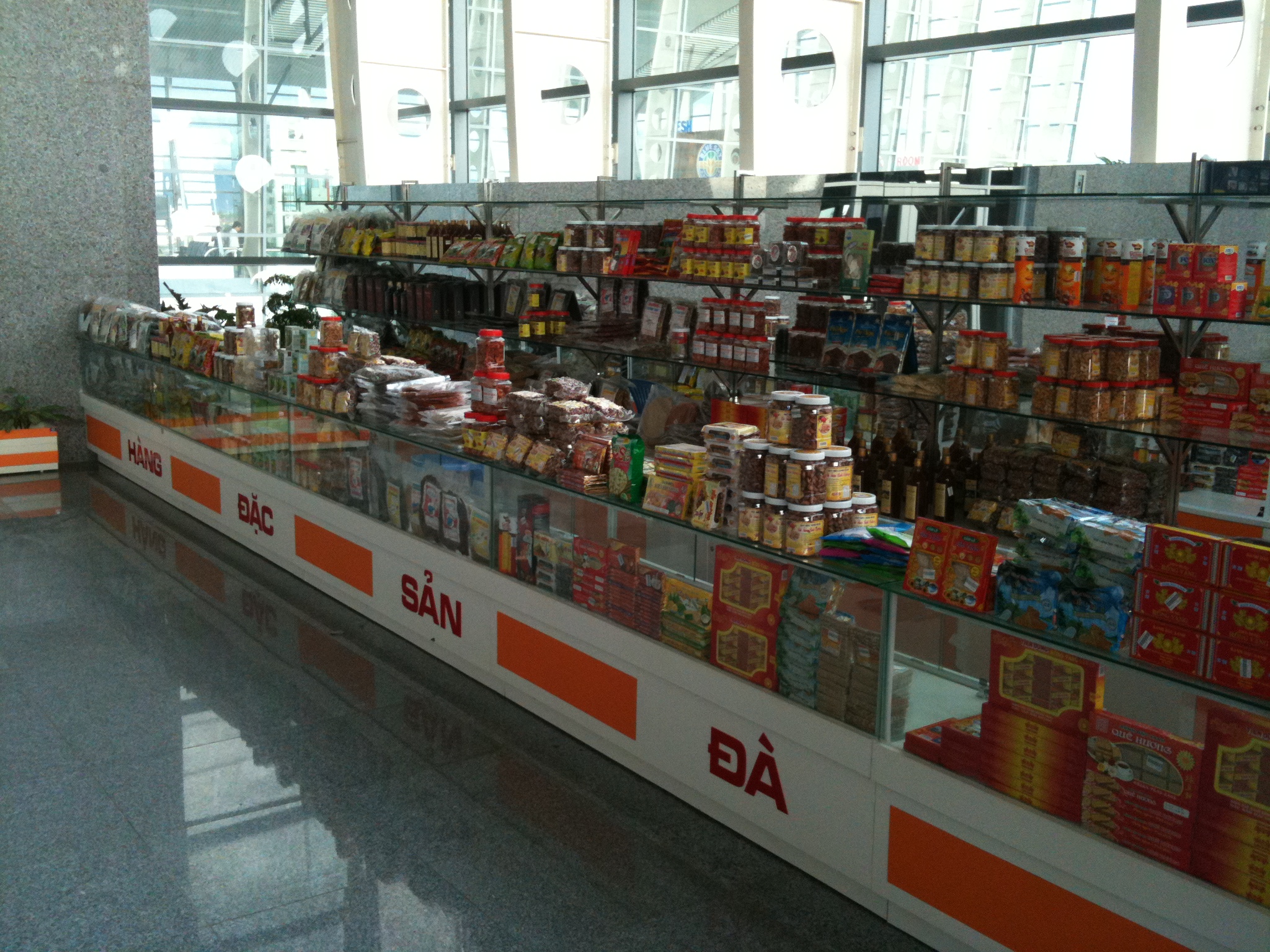 Cửa hàng đặc sản tại sân bay minh họa việc kiểm tra gói hàng trước khi mang về