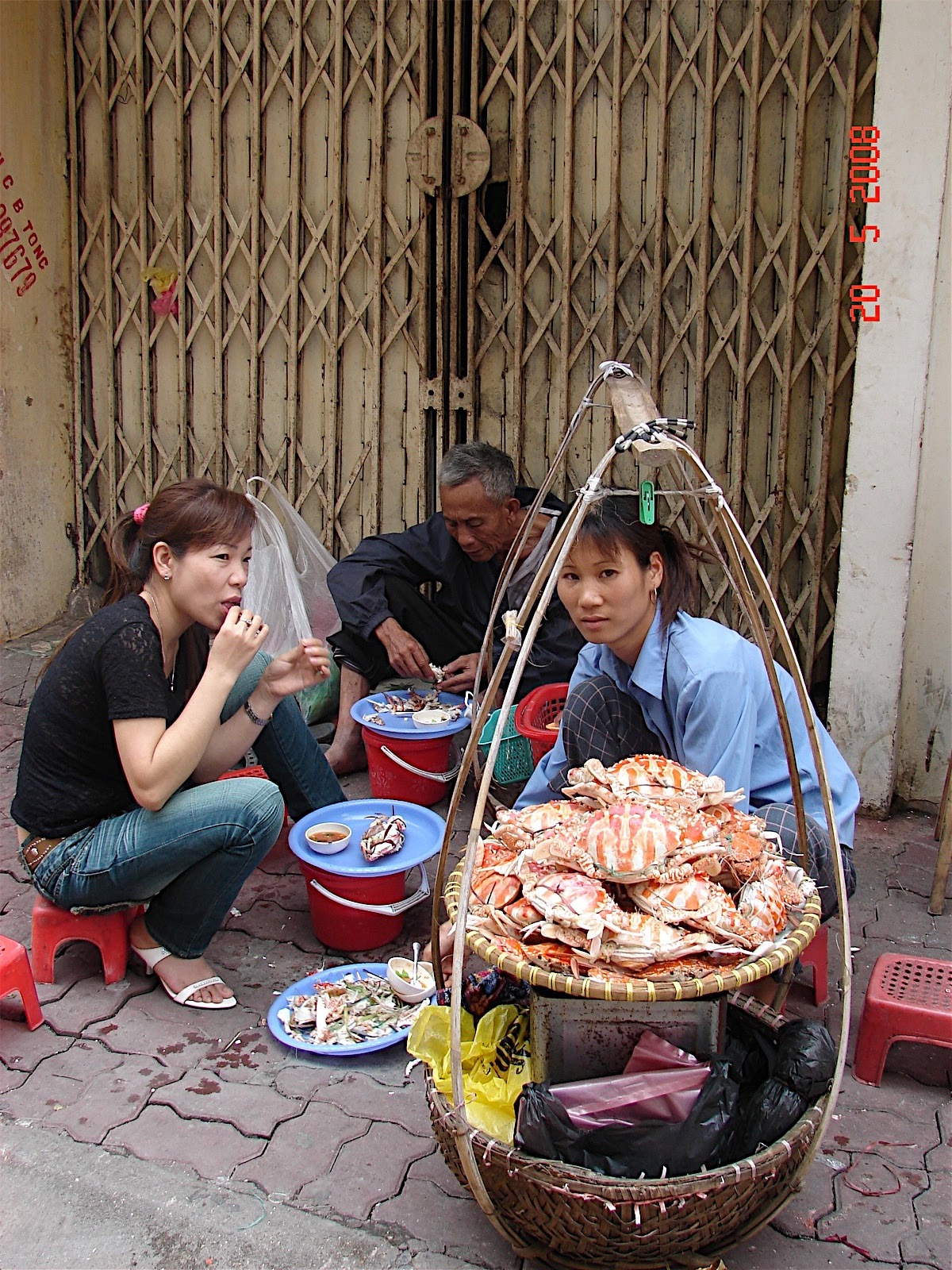 Quầy cua đường phố Hà Nội với người bán và thực khách minh họa việc hỏi món trong tour ẩm thực