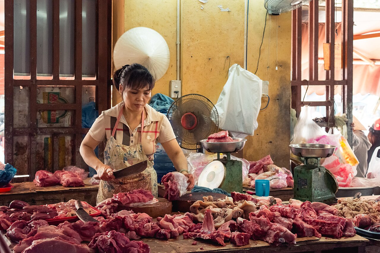Người bán sơ chế thịt tại một chợ thực phẩm minh họa giới hạn của việc đánh giá an toàn qua ảnh